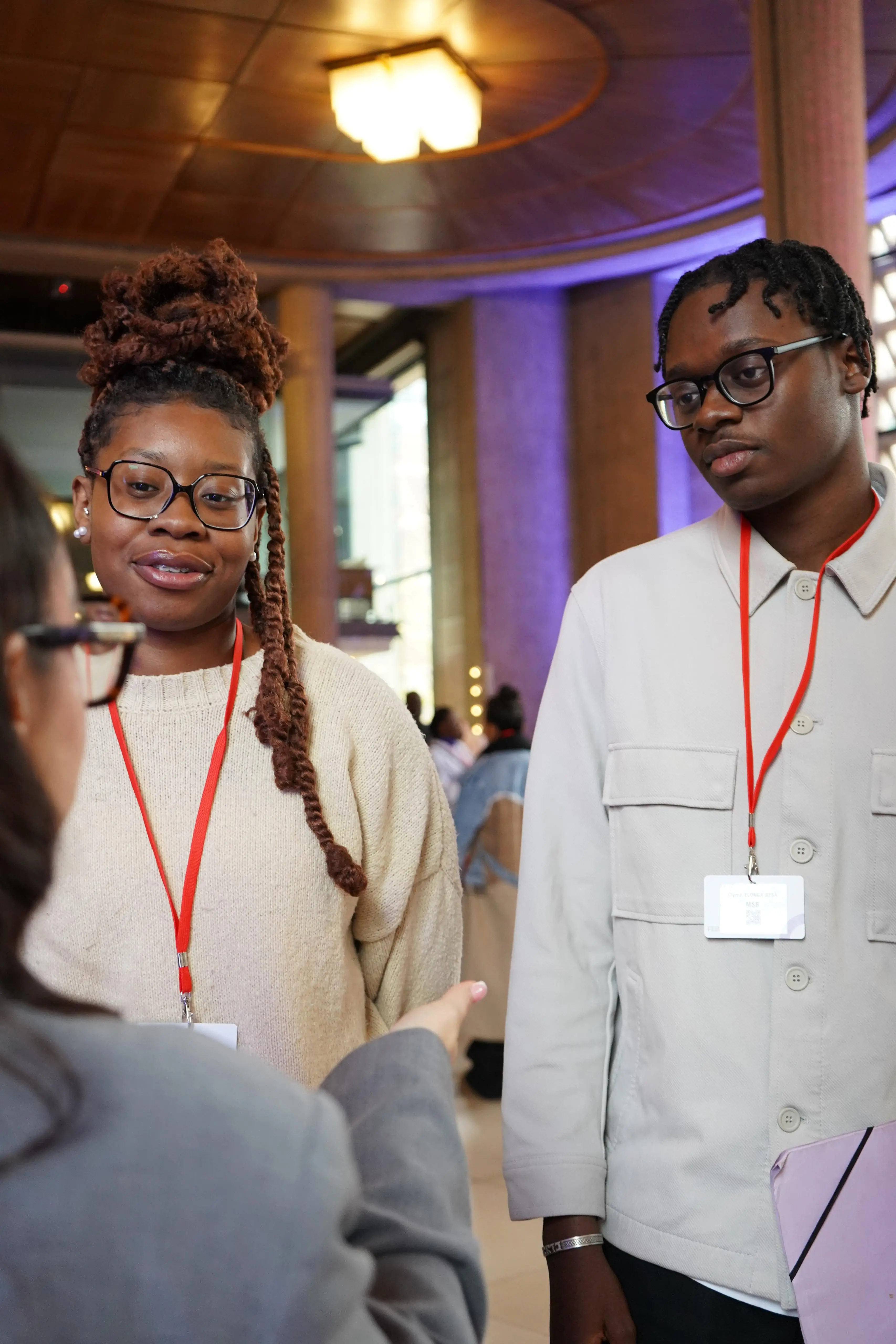 Deux étudiants de MSB souriants, badges autour du cou, en pleine discussion