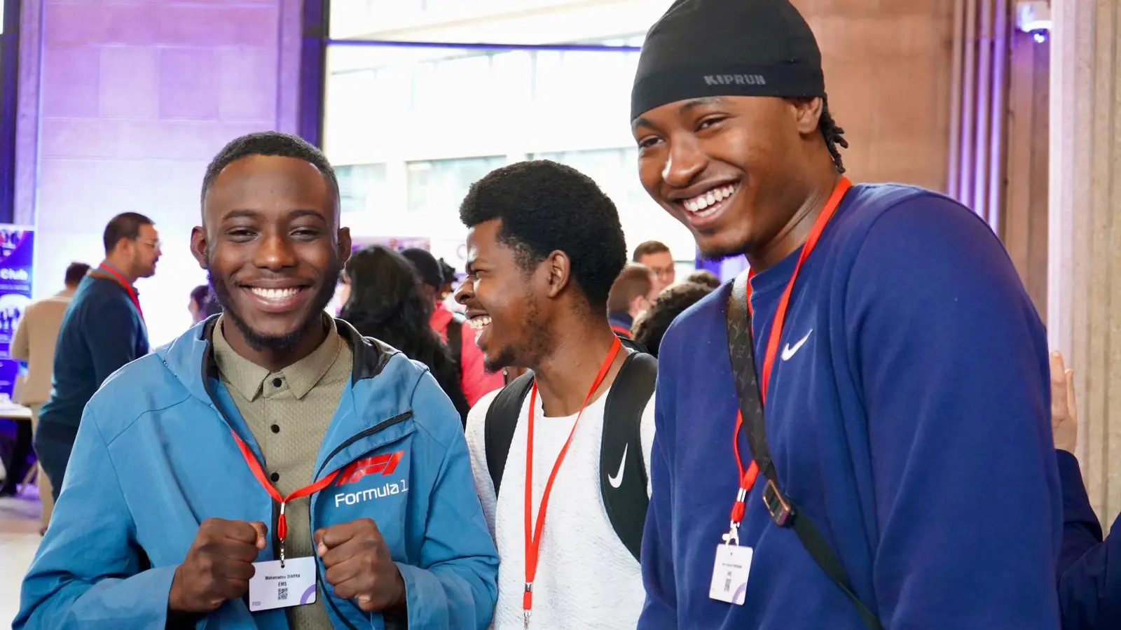 Groupe d'étudiants souriants, badges autour du cou, lors d'un événement de l'école