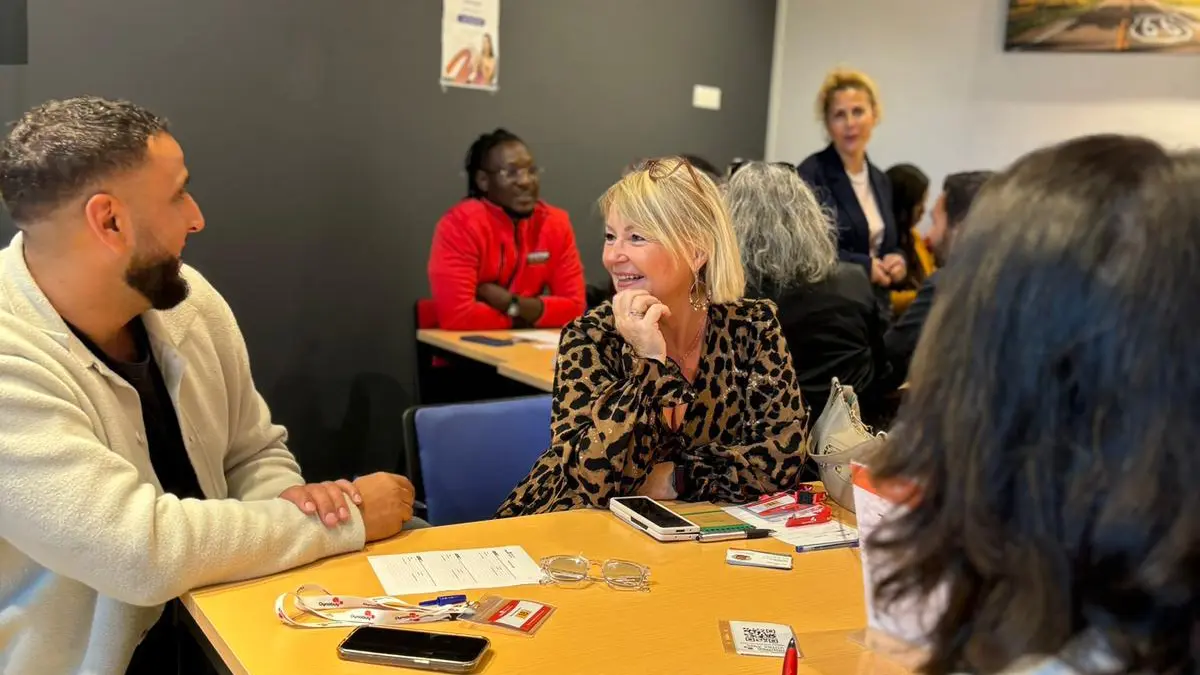 Étudiants et chefs d'entreprise partenaires attablés et souriants lors d'une rencontre à l'école